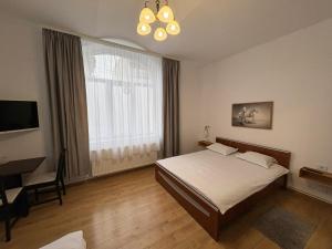 ein Schlafzimmer mit Bett, Schreibtisch und Fenster in der Unterkunft Vila Ada in Bukarest