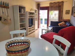 a living room with a table and a couch at Oasis Palm Mar by HelloApartments in Palm-mar