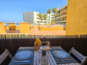 a table with a tea pot and plates on a balcony at Arena Beach by HelloApartments in Puerto de Santiago