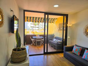 a living room with a couch and a table at Arena Beach by HelloApartments in Puerto de Santiago