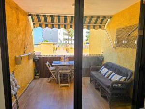 a patio with a table and chairs and a couch at Arena Beach by HelloApartments in Puerto de Santiago