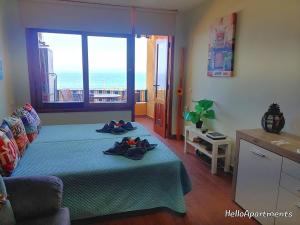 a bedroom with a bed with a view of the ocean at Sea View Playa Arena by HelloApartments in Puerto de Santiago +28 photos