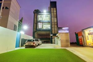 ラクナウにあるComfort Stay - Near Airportの建物の前の駐車場に駐車された車