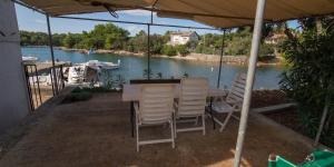 a table and chairs on a patio with a view of a river at JOSIP A3 in Nerezine