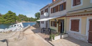 a boat is docked next to a building next to the water at JOSIP A3 in Nerezine