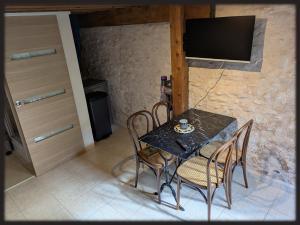 a dining room with a table and chairs and a television at Le Mas des Condamines in Canet