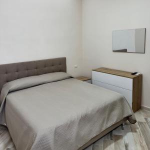 a small bedroom with a bed and a night stand at Casa Vacanze Vienna in Boscotrecase