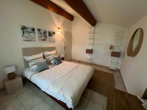 a bedroom with a large bed with white sheets and blue pillows at La Parenthèse Balnéo in Donzère