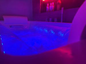 a dark room with a sink and a purple light at La Parenthèse Balnéo in Donzère