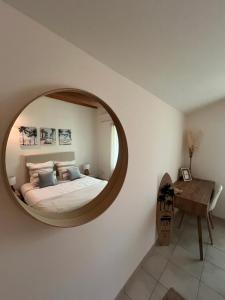 a bedroom with a large circular mirror on the wall at La Parenthèse Balnéo in Donzère