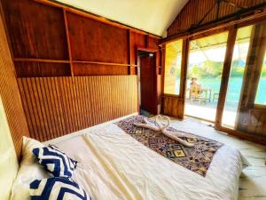 een slaapkamer met een bed met een houten muur bij Ban Hao Riverstay Muang Fuang in Muang Fuang