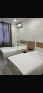 a bedroom with two beds and a window at Van Park Hotel in Shymkent