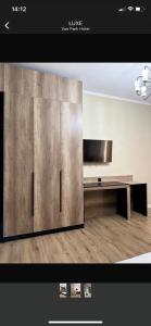 a living room with a tv and a wooden floor at Van Park Hotel in Shymkent +6 photos
