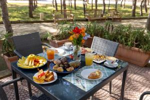 een tafel met borden met eten en drinken erop bij Residence Punta Longa in Favignana