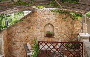 Pet Friendly Apartment In Bol With Wifi في بول: مبنى حجري مع مقعد ونافذة