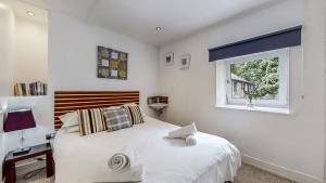 ein Schlafzimmer mit einem großen weißen Bett und einem Fenster in der Unterkunft Finest Retreats - Old Barn at Ormidale House in Clachan of Glendaruel