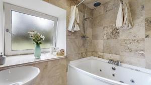 ein Badezimmer mit Badewanne und Waschbecken und einem Fenster in der Unterkunft Finest Retreats - Old Barn at Ormidale House in Clachan of Glendaruel + 25 Fotos