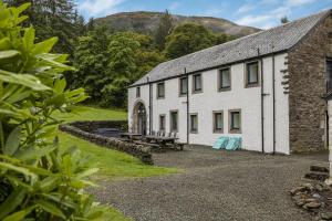 ein weißes Gebäude mit einem Picknicktisch davor in der Unterkunft Finest Retreats - Old Barn at Ormidale House in Clachan of Glendaruel