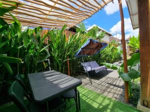 a patio with a table and an umbrella and some plants at Tiny House Bali in Kerobokan