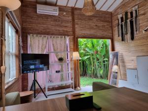 a living room with a tv and a large window at Tiny House Bali in Kerobokan