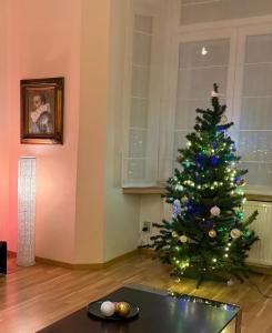 einen Weihnachtsbaum in einem Wohnzimmer mit einem Tisch in der Unterkunft Super Old Town in Prag