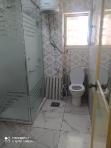Un baño con inodoro y ducha de cristal. en city square alex, en Alejandría 17 fotos más