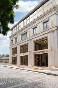 a large white building with windows on a street at Gopuram Grand in Madurai