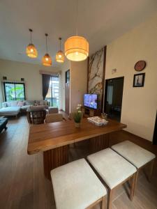 a living room with a wooden table and chairs at Villa indah sudungdewo in Wonosobo