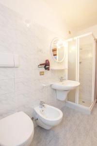 a white bathroom with a toilet and a sink at Casa Lori Green Holiday in Ledro