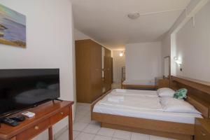 a bedroom with a bed and a flat screen tv at B&B sv. Martin in Mali Lošinj