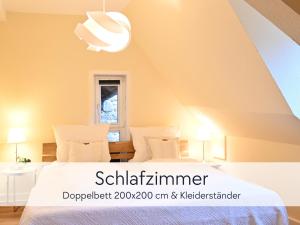 ein Schlafzimmer mit einem weißen Bett und einem Fenster in der Unterkunft TÜRMERSTUBE - Apartment in der Hinterburg Schlitz - direkt an der "Größten Kerze der Welt" - mit Aufzug, Parkplatz, E-Ladestation & Garten - Hunde willkommen in Schlitz