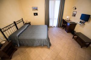 a bedroom with a bed and a desk and a television at Hotel del Rio Srl - RISTORANTE e Azienda agricola in Casinalbo