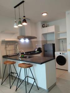 a kitchen with a counter with stools and a sink at Sutera Avenue near Gleaneagle KK King Bed in Kota Kinabalu