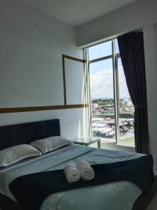 a bedroom with a bed with two towels on it at Sutera Avenue near Gleaneagle KK King Bed in Kota Kinabalu