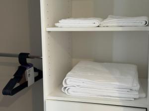 ein Regal mit weißen Handtüchern und einem Haartrockner in der Unterkunft Hampton Luxe Retreat 4BR Pet Friendly in Melbourne + 33 Fotos