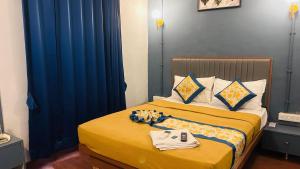 a hotel room with a bed with blue curtains at Hotel Cozy Inn in Kālundri