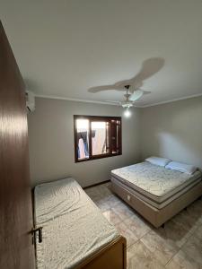 ein Schlafzimmer mit zwei Betten und einem Fenster in der Unterkunft Fresh house enjoy the beach in the summer! in Capão da Canoa