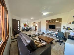 ein Wohnzimmer mit einer Ledercouch und einem Tisch in der Unterkunft Fresh house enjoy the beach in the summer! in Capão da Canoa