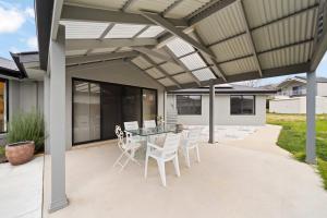 un patio con mesa y sillas bajo toldo en Beautiful Spacious Home in a Serene Setting, en Eglinton