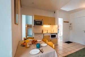 a kitchen with a table with plates on it at Refuge des Cols Verts Parking Cozy Relaxing in Saint-Gervais-les-Bains +23 photos