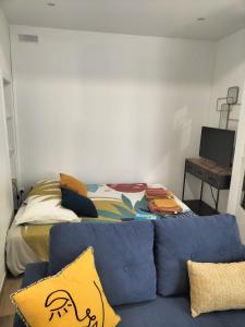 ein Wohnzimmer mit einer Couch und einem Bett in der Unterkunft Le Ty Logis in Vannes
