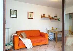 een oranje bank in een woonkamer met een tafel bij Holihome Sofy Mare in Tortoreto Lido +17 foto's