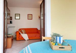 een woonkamer met een oranje bank in een kamer bij Holihome Sofy Mare in Tortoreto Lido