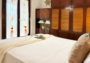 een slaapkamer met een wit bed en houten kasten bij Holihome Sofy Mare in Tortoreto Lido