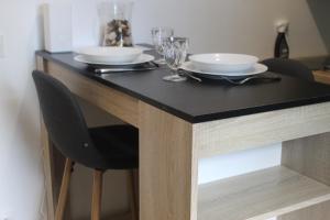 einen Esstisch mit 2 Tellern und Gläsern darauf in der Unterkunft Le Ty Logis in Vannes