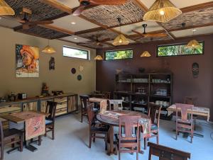 a dining room with tables and chairs and windows at Explorers Kilimanjaro Boutique Hotel in Moshi