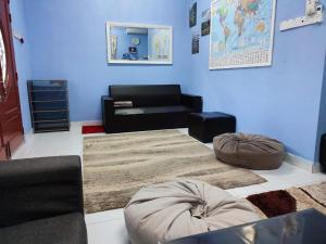 a living room with a couch and a rug at Homestay Tepi Sungai Golok in Rantau Panjang
