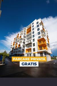 普洛耶什蒂Real Resort的一栋大型白色公寓楼，阳台是橙色的。