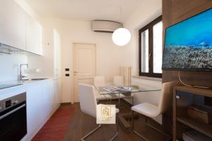 een eetkamer met een glazen tafel en een televisie bij GoldenSuitesItaly Piazza Duomo Luxury Apartment 3 in Trento