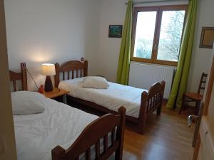 Un dormitorio con dos camas y una ventana. en La Bertrandie, en Florimont-Gaumiers